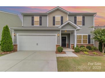 Two-story home featuring neutral siding, black shutters, a two-car garage and manicured landscaping at 2037 Christopher Wood Ct, Fort Mill, SC 29707