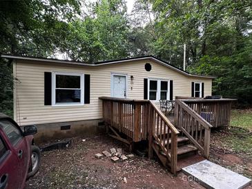 Cozy single-story home featuring a wooden deck, black shutters, and light beige siding at 226 Lake Sylvia Rd, Lincolnton, NC 28092