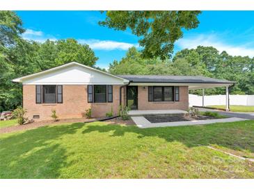 Charming brick home featuring manicured lawn, a covered carport, and a welcoming front entrance at 2323 Brookwood Rd, Lincolnton, NC 28092
