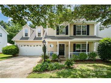Charming two-story home featuring a welcoming front porch and attached two-car garage with a beautifully landscaped front yard at 3702 Brookstone Trl, Indian Trail, NC 28079