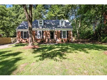 Charming brick home with dormer windows and a well-maintained front yard surrounded by mature trees at 6127 Eagle Peak Dr, Charlotte, NC 28214