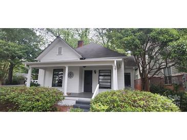Charming home featuring white siding, a covered porch, and lush green landscaping at 1126 Clement Ave, Charlotte, NC 28205