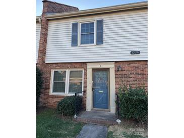 Charming townhome with brick facade, blue door and shutters, and well-maintained landscaping at 1228 Archdale Dr # G, Charlotte, NC 28217