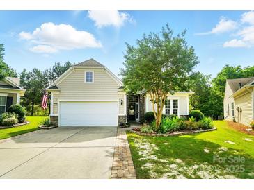 Charming home featuring a two-car garage, manicured lawn, and beautiful landscaping with a stone-accented facade at 15116 Legend Oaks Ct, Fort Mill, SC 29707