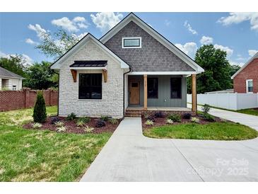 Charming home with stone and siding exterior, landscaped front yard, and inviting covered porch at 1721 S New Hope Rd, Gastonia, NC 28054