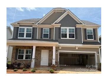 Charming two-story home featuring a welcoming front porch and attached two-car garage at 180 Ella Claire Dr, York, SC 29745