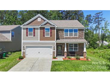 Charming two-story home with a blend of stone and siding, featuring an attached garage and well-manicured lawn at 2527 Linhay Dr, Charlotte, NC 28216
