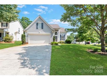 Charming home with a well-manicured lawn, attached garage, and welcoming entrance at 1013 Nez Perce Ln, Monroe, NC 28110