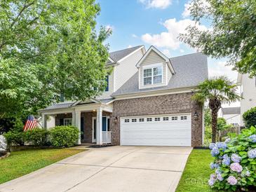 Charming two-story home features a brick facade, well-manicured lawn, and a spacious two-car garage at 1016 Yellow Daisy Dr, Matthews, NC 28104