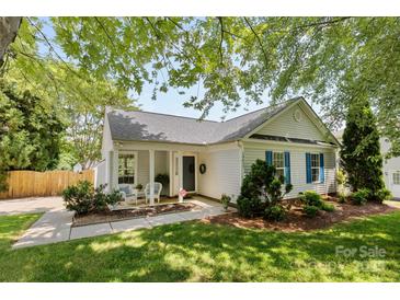 Charming single-story home featuring a cozy front porch with seating and lush landscaping at 10621 Glenmac Rd, Charlotte, NC 28215