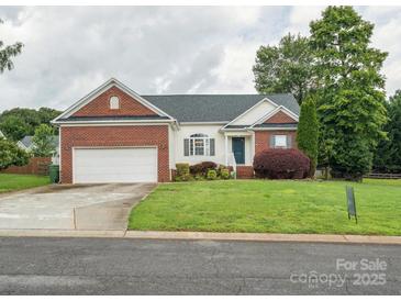 Charming home featuring a brick and vinyl exterior, attached garage and a well-manicured front lawn at 116 Birchwood Ct, Mount Holly, NC 28120