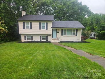 Charming home with manicured lawn, fresh landscaping, and a welcoming light blue front door at 1645 Brookdale Ave, Charlotte, NC 28210
