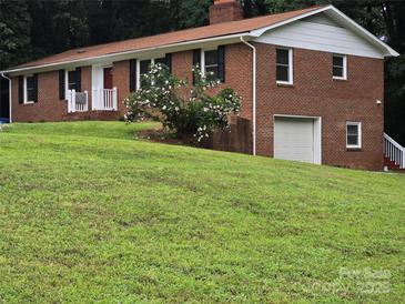 Two-story brick home with a well-manicured lawn and mature landscaping offers great curb appeal at 1660 Songwood Rd, Concord, NC 28025