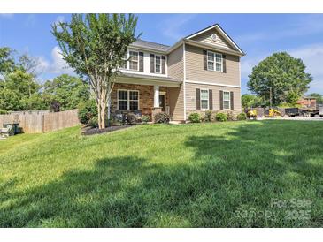 Charming two-story home with stone accents and well-manicured lawn on a sunny day at 19455 Smith Cir, Cornelius, NC 28031