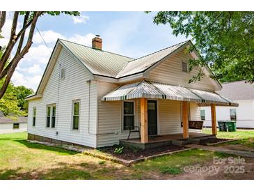 Charming home featuring a porch swing, awning, and well-maintained lawn at 505 S Eastway Dr, Troutman, NC 28166
