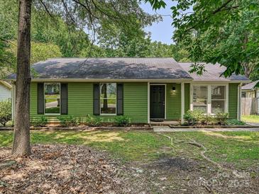 Charming single-story home featuring a black front door and lush green surroundings at 5811 Rock Hollow Dr, Charlotte, NC 28212