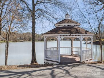 Picturesque white gazebo on the shore of a tranquil lake, perfect for relaxation and enjoying scenic views at 714 Deerbrook Ln, Tega Cay, SC 29708