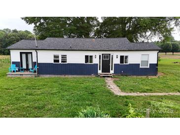 Charming one-story home features a blue and white exterior, black front door and well-maintained lawn at 751 Northbrook Iii School Rd, Vale, NC 28168