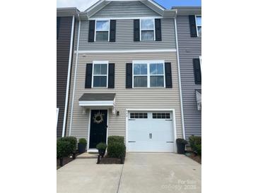Charming townhouse exterior with light siding, black shutters, and attached one car garage and well maintained landscaping at 999 Rushing Ln # 13, Fort Mill, SC 29715