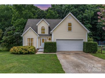 Charming yellow home featuring an attached garage and a beautifully landscaped front yard at 270 Kilmer Ln, Mooresville, NC 28115