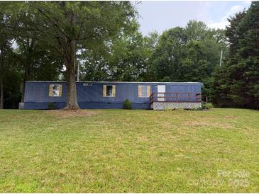 A manufactured home with a blue exterior and a grassy front yard at 41042 Dennis Rd, Albemarle, NC 28001