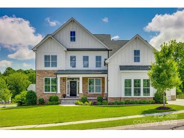Beautiful two-story home featuring stone accents, a well-manicured lawn, and a welcoming front porch at 509 Abelia Ln, Tega Cay, SC 29708