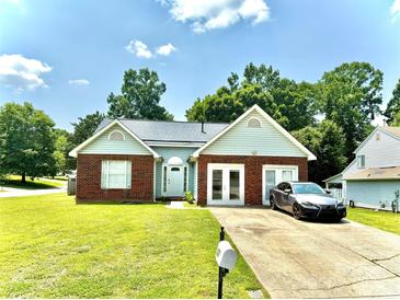 Charming one-story brick home featuring an attached garage and a well-manicured front lawn at 5728 Rocbridge Ln, Charlotte, NC 28208