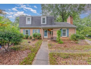 Charming two-story brick home with blue shutters and a landscaped front yard with a wooden porch swing at 6577 Stoney Ridge Rd, Matthews, NC 28104