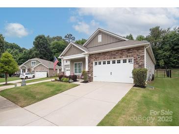 Charming home featuring stone accents, a well-manicured lawn, and a two-car garage at 7328 Strawberry Fields Ln, Charlotte, NC 28278