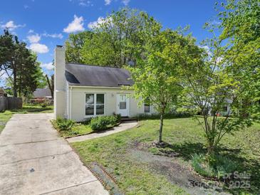 Charming single-story home featuring a brick chimney, well-kept lawn, and mature trees at 8520 Mission Hills Rd, Charlotte, NC 28227