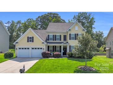 Charming two-story home with a well-manicured lawn, a two-car garage, and a welcoming front porch at 11618 Macallano Dr, Charlotte, NC 28215