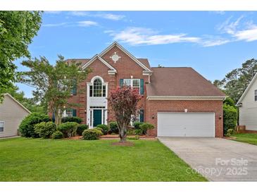 Charming two-story brick home with a well-manicured front lawn and attached two-car garage at 3830 Waters Reach Ln, Indian Trail, NC 28079