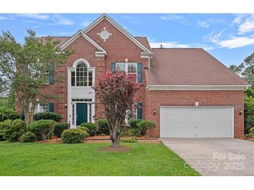 Two-story brick home featuring a well-maintained lawn and a two-car garage at 3830 Waters Reach Ln, Indian Trail, NC 28079