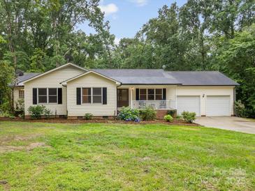 Charming home features a front porch, manicured lawn, and an attached two-car garage at 5322 Bridgeview Dr, Iron Station, NC 28080