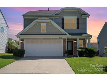 Charming two-story home featuring a stone facade and attached garage with a well-manicured lawn at 6156 Kilchurn Dr, Fort Mill, SC 29707