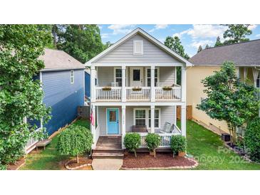 Charming two-story home with double front porches, bright blue door, and manicured landscaping at 12304 Huntersville Concord Rd, Huntersville, NC 28078
