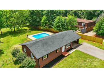 Aerial view of a brick home with a backyard pool and a spacious, tree-lined lawn at 1837 6Th Nw Ave, Hickory, NC 28601