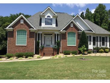 Charming brick home boasts meticulous landscaping and a welcoming front entrance, perfect for curb appeal at 1842 Caroline Way, Fort Mill, SC 29715