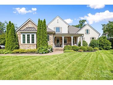 Beautiful home with a stone and stucco exterior, manicured lawn, and inviting front porch at 2501 Christenbury Hall Nw Ct, Concord, NC 28027