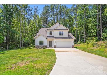 Charming two-story home with attached garage, long drive, and surrounded by mature trees at 2612 Cold Springs Rd, Concord, NC 28025