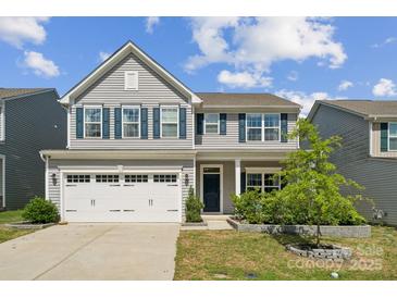 Charming two-story home with blue shutters, a white garage door, and a well-manicured front yard at 1311 Rowan Ln, Monroe, NC 28110