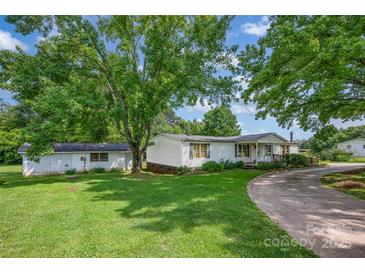 Charming single-Gathering home with a large, lush front yard and detached garage surrounded by mature trees at 1532 Buffalo Shoals Rd, Claremont, NC 28610