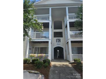 Inviting condominium entrance with multiple levels and manicured landscaping, offering a warm welcome at 3944 Town Center Rd, Harrisburg, NC 28075