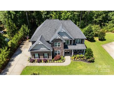 Stunning aerial view of a two-story home featuring lush landscaping, and a beautiful gray roof at 3963 Harmattan Dr, Denver, NC 28037