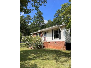 Charming single-story home with brick foundation and white siding, surrounded by lush greenery at 418 Cedar Grove Rd, Clover, SC 29710