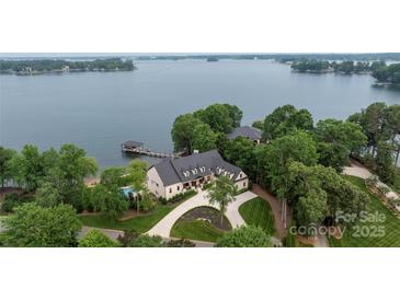 Stunning aerial view of lakefront home, boasting a private dock, pool and meticulously landscaped grounds at 8170 Bay Pointe Dr, Denver, NC 28037