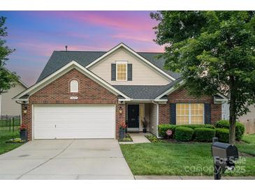Charming single-Gathering home featuring a well-manicured lawn, brick accents and two-car garage at 10211 Dominion Village Dr, Charlotte, NC 28269