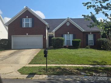 Charming brick home featuring a well-maintained lawn and a two-car garage at 13409 Planters Row Dr, Charlotte, NC 28278