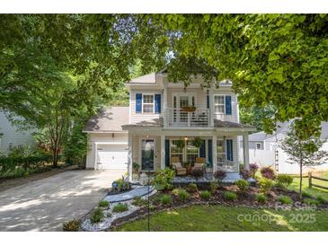 Charming two-story home featuring a welcoming front porch, upper balcony, attached garage and beautifully landscaped yard at 4439 Brandie Glen Rd, Charlotte, NC 28269