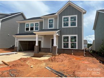 New two-story home boasts a gray exterior, white trim, brick accents, and an attached two-car garage at 634 Amberjack Pl # 77, York, SC 29745